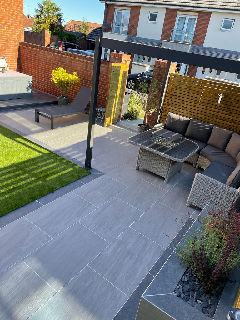Completed grey paving with outdoor seating and pergola from the original project gallery